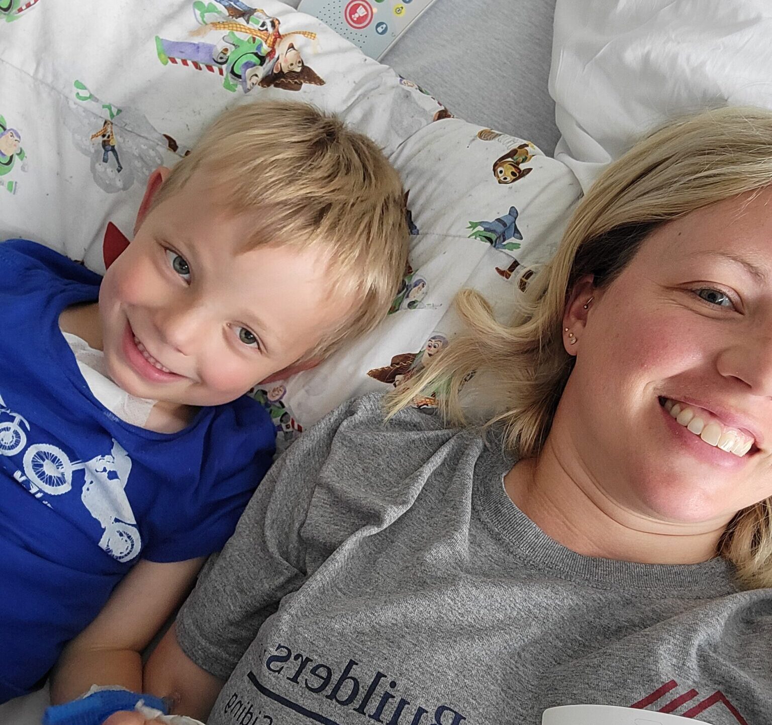 boy and mom laying in hospital bed