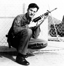 Black and white photo of a man in army uniform holding a rifle