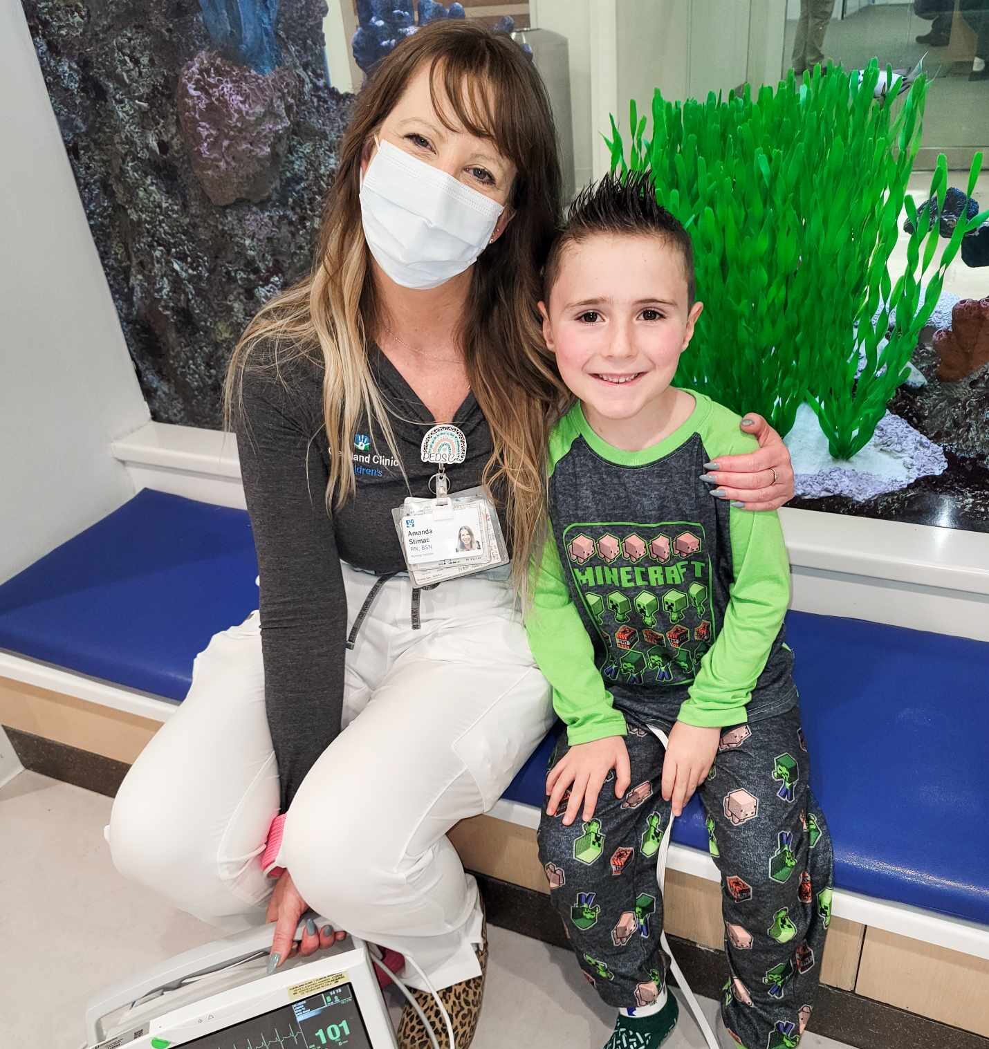 Young boy and nurse with monitor by aquarium