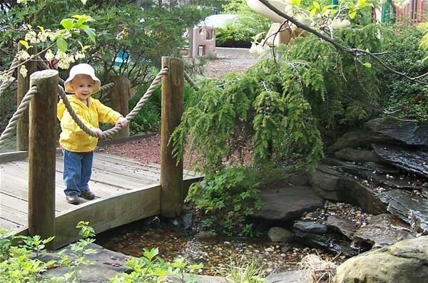 Child on a wooden bridge over a creek
