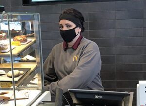 Sarah working behind the counter at the McDonald's she manages. 