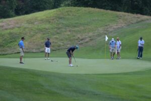 Golfers on putting green.