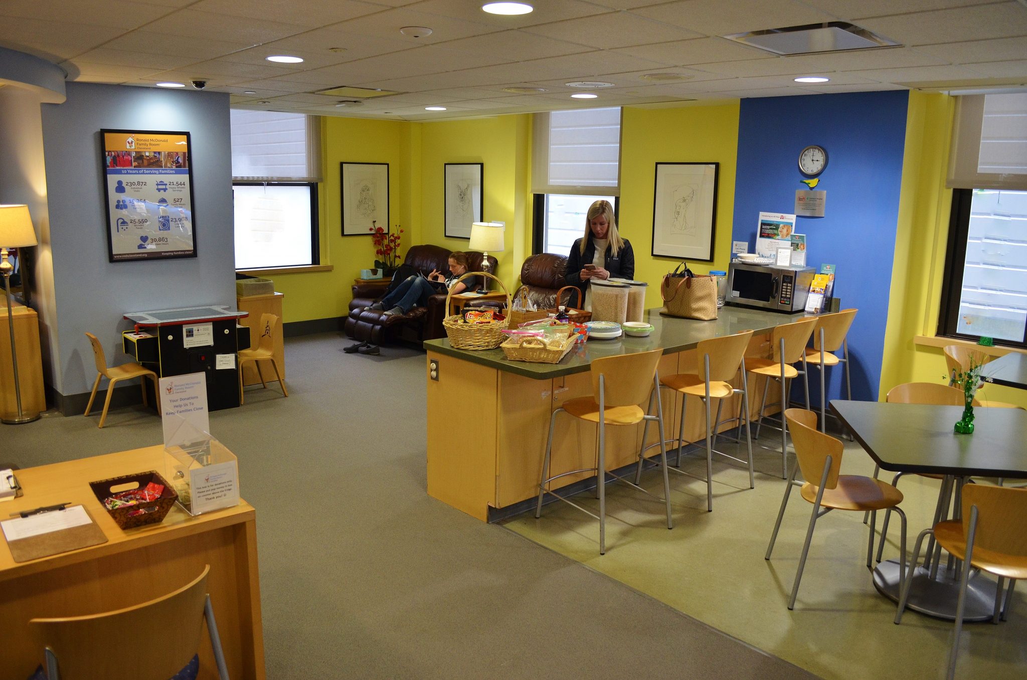 The Family Room at Cleveland Clinic Children’s has adjoining ares marked by cheery blue and yellow. there is a counter and table in the kitchenette, a game area, and a lounge with comfortable seating