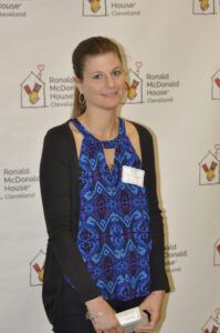 woman in blue and black with name tag and award