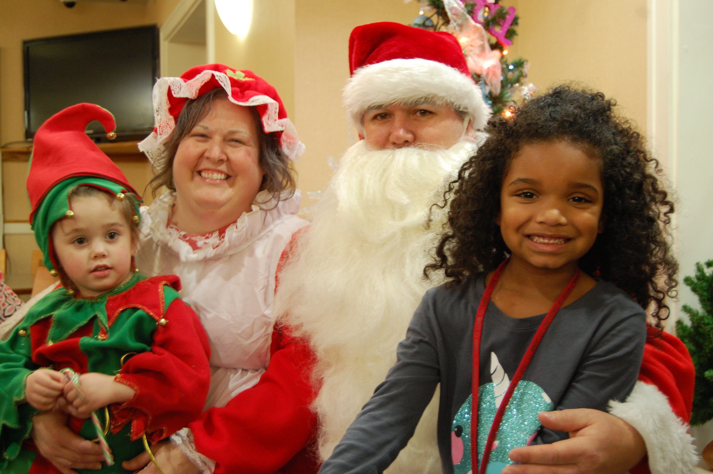 Mr. and Mrs. Santa pose with children