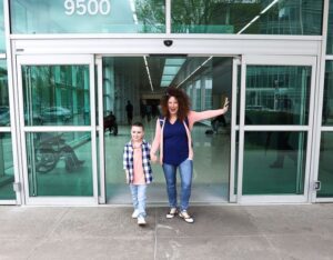 boy and mother holding hands leaving hospital 