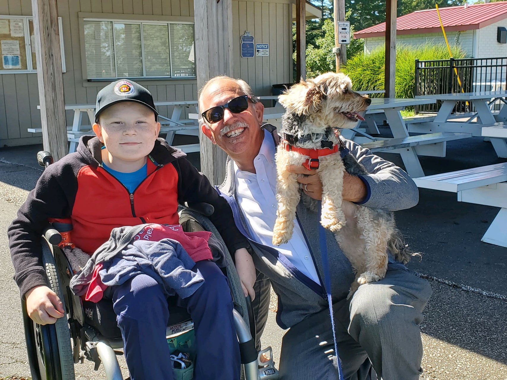 boy in wheelchair with man and dog