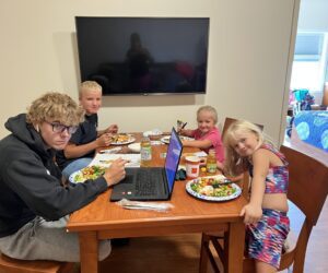 Picture of a family eating at a wooden table