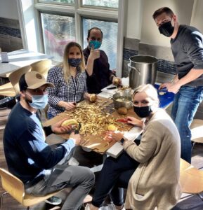 A group of people chopping vegetables around a table.