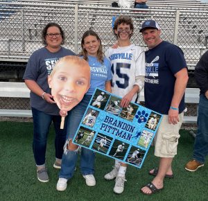 family at lacrosse game with mom, dad, sister, and son.