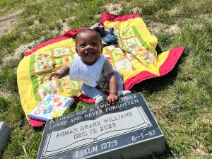 Little boy smiling at headstone