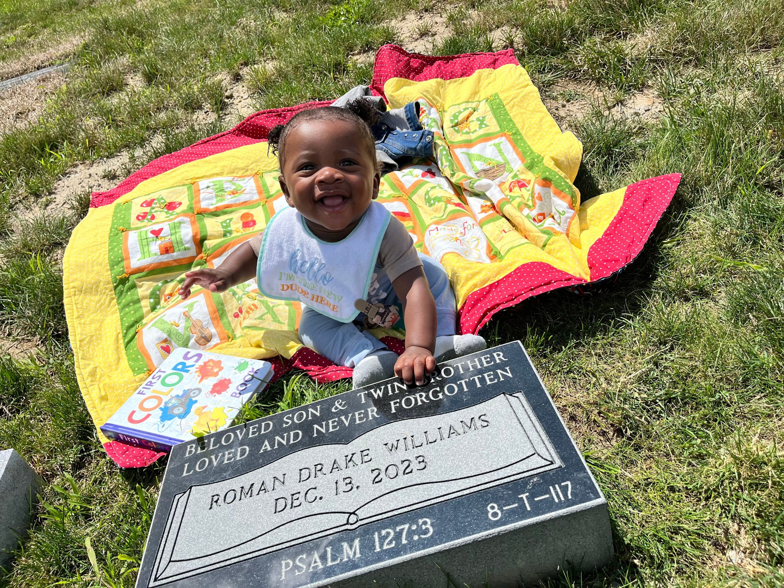 Little boy smiling at headstone