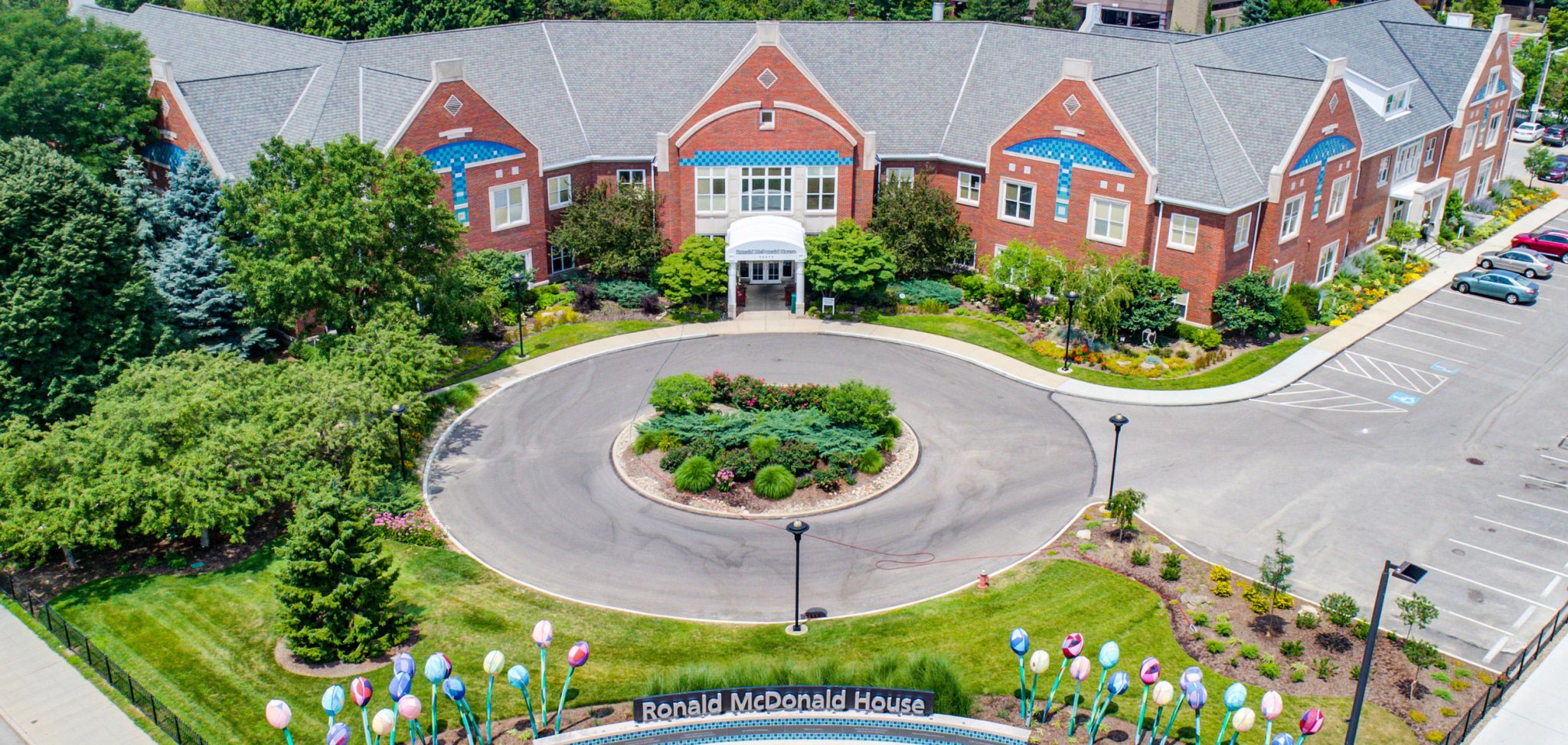 The Cleveland Ronald McDonald House, shown from an overhead view. It is a brow brick building with 4 floors, surrounded by attractive landscaping.