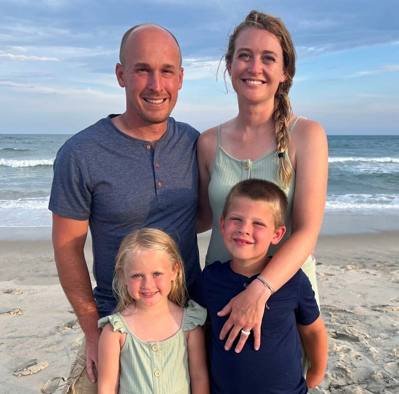 family standing on the beach