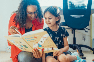 Woman reading to child from a children's book.