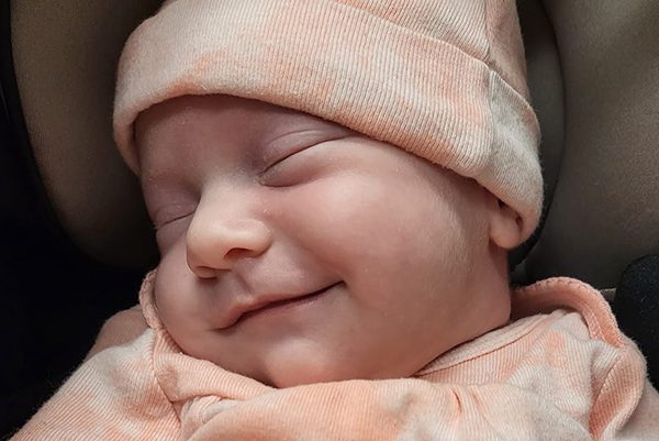 Baby Haddie sleeps with a smile on her face