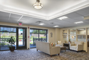 The lobby of the Akron Ronald McDonald House has large windows and comfortable couches and chairs. It is decorated in welcoming cream colors. 