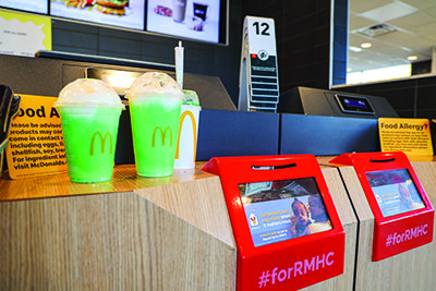 McDonalds counter with shamrock shakes and donation boxes
