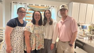 Four young adults standing and smiling for photo