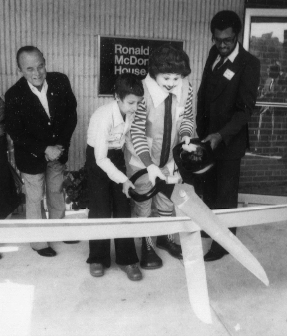 black and white photo Ronald McDonald cutting ribbon