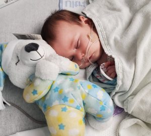 baby sleeping with stuffed dog